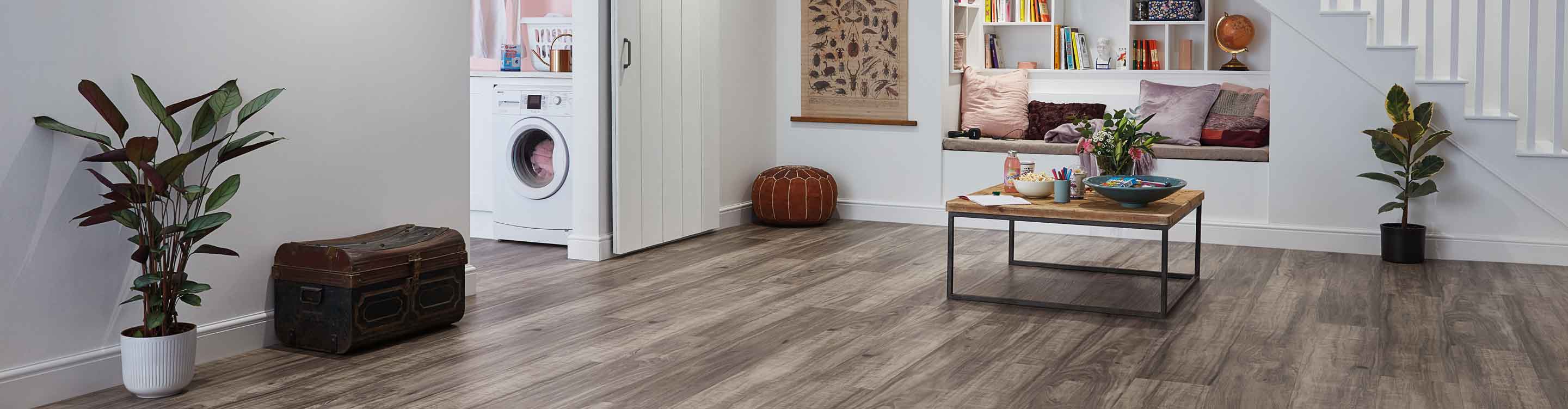 gray look luxury vinyl flooring in modern finished basement with reading nook and sliding barn doors to laundry room